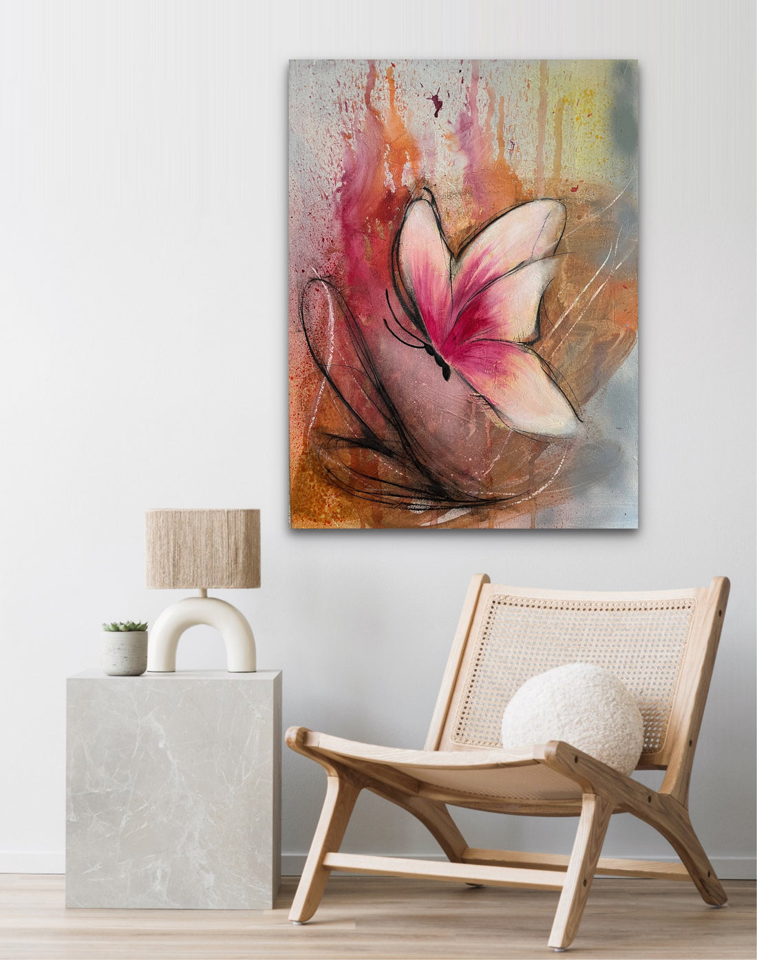 Abstract butterfly artwork with a pink and cream butterfly centered over a textured background of orange, brown, gray, and yellow paint drips and splatters.